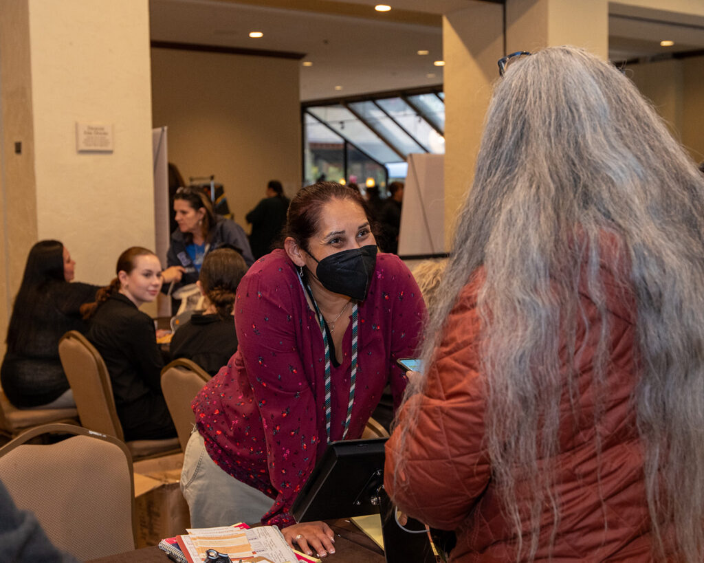 A NICWA volunteer smiling at the annual conference registration desk.