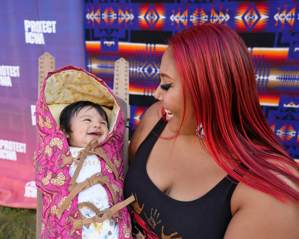 Native mother with baby in cradle board.