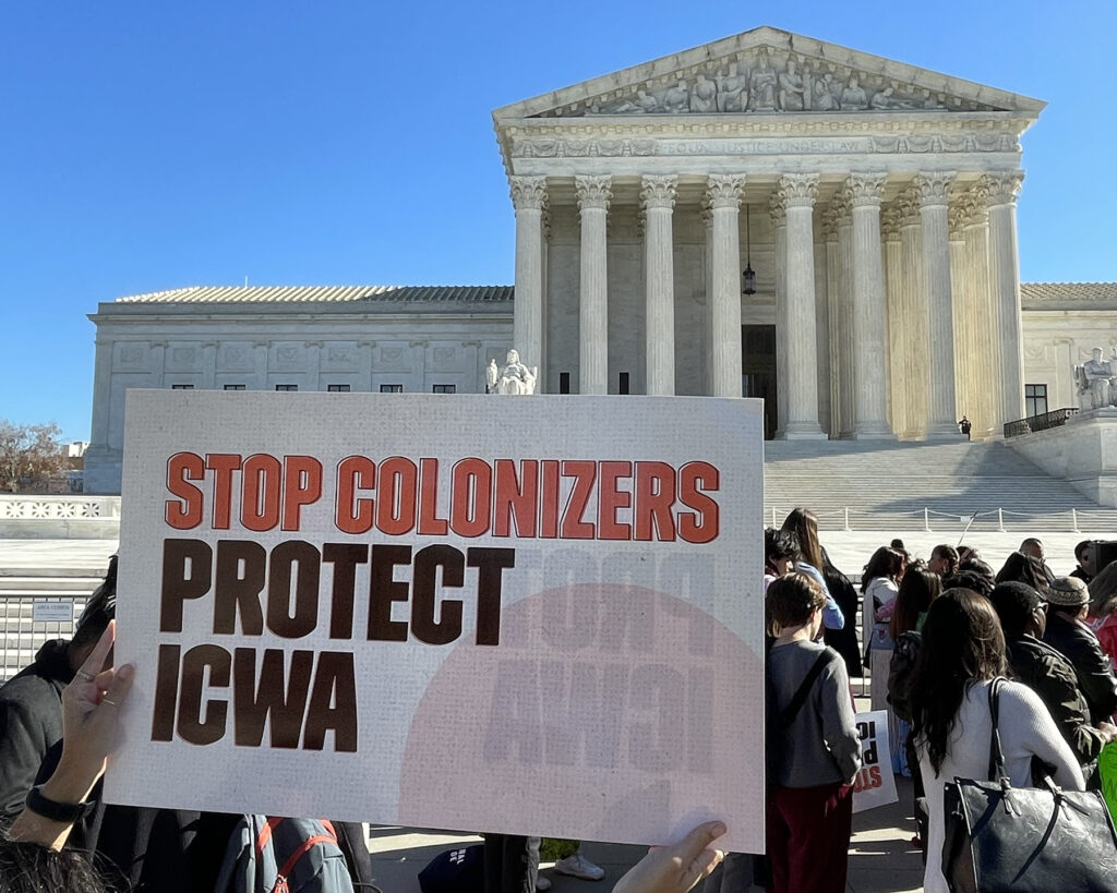 Protest sign held up outside the White House. The sign reads, "Stop Colonizers. Protect ICWA."